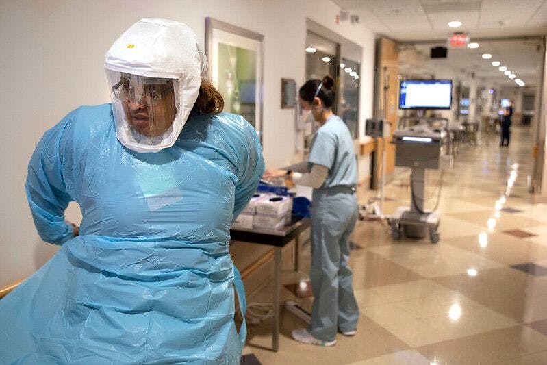 Patricia Williams-Forgenie, a registered nurse at Penn State Health Holy Spirit Medical Center, dons personal protective equipment before entering the room of a COVID-19 patient on Wednesday, Jan. 5, 2022. (Photo courtesy of Penn State Health.)